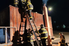 Moose Lake firefighter in full gear facing an intense structure fire